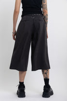 Grey pinstripe longline tailored shorts with eyelet belt and D-ring hardware, worn by model