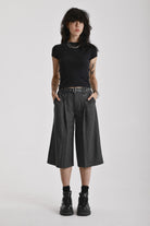 Grey pinstripe longline tailored goliath shorts with silver eyelet belt and D-ring hardware, worn by model