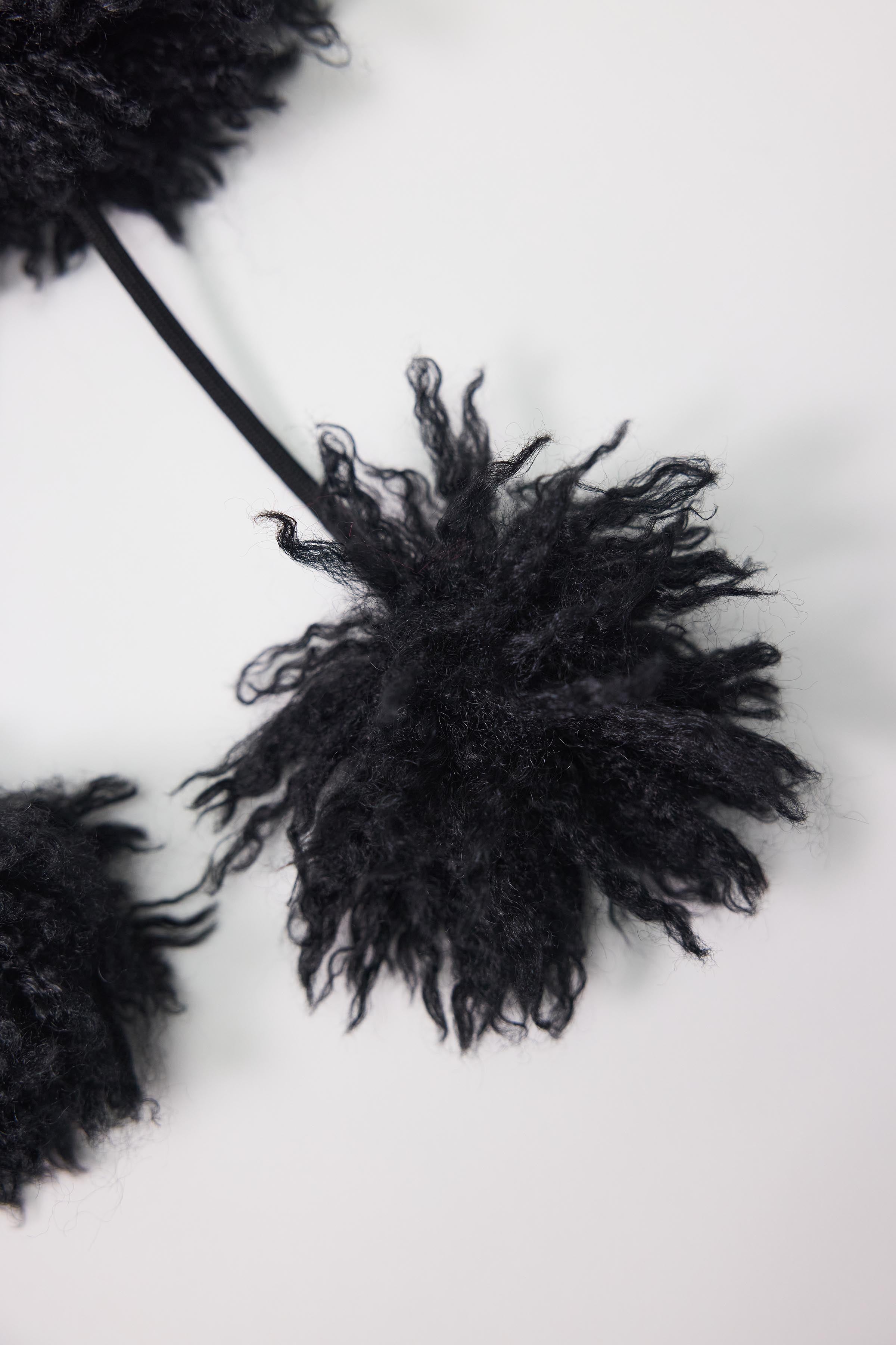 Black shaggy faux fur trapper hat with pom poms