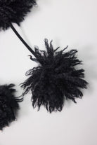 Black shaggy faux fur trapper hat with pom poms