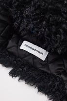 Black shaggy faux fur trapper hat with pom poms