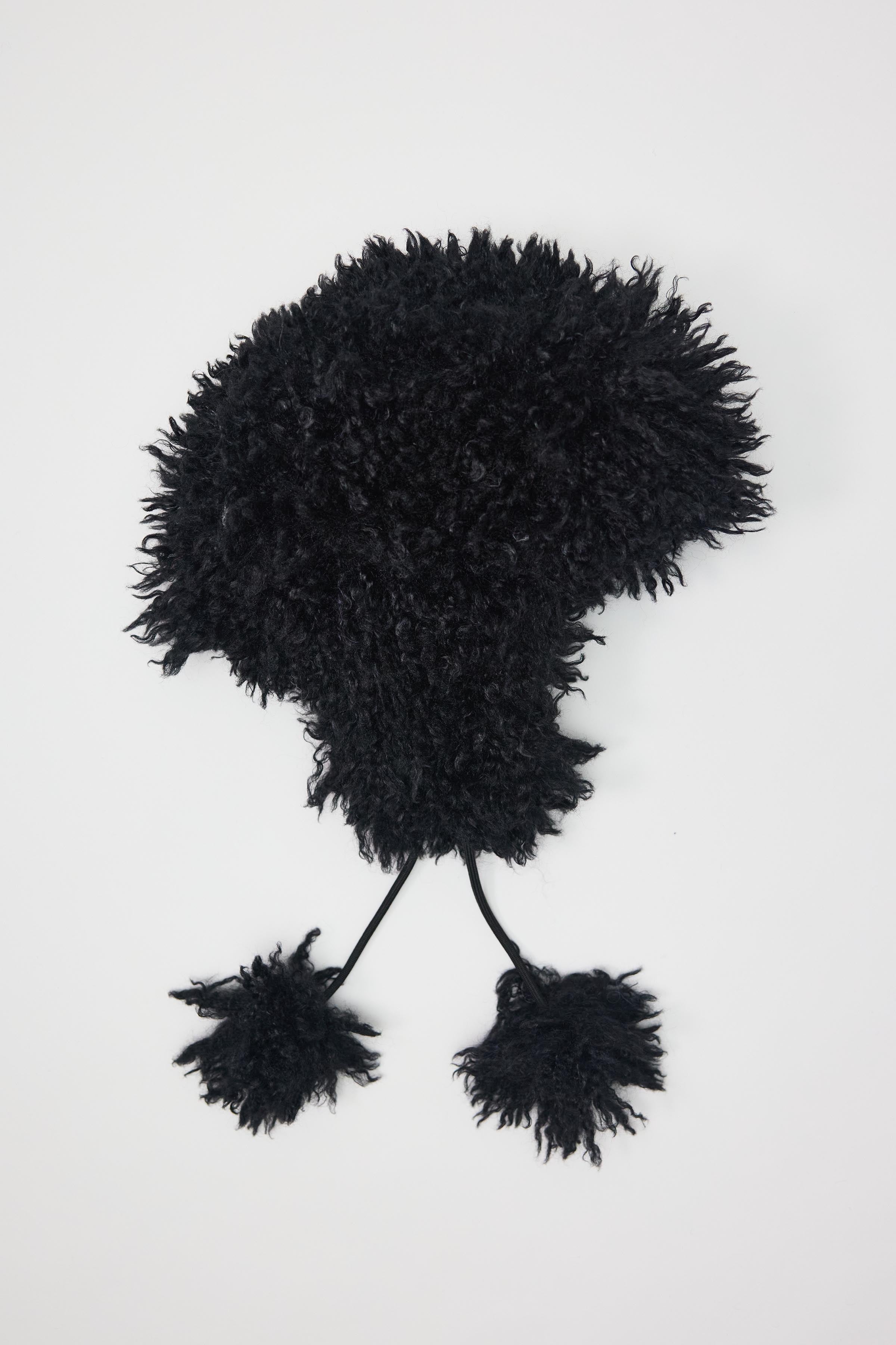 Black shaggy faux fur trapper hat with pom poms