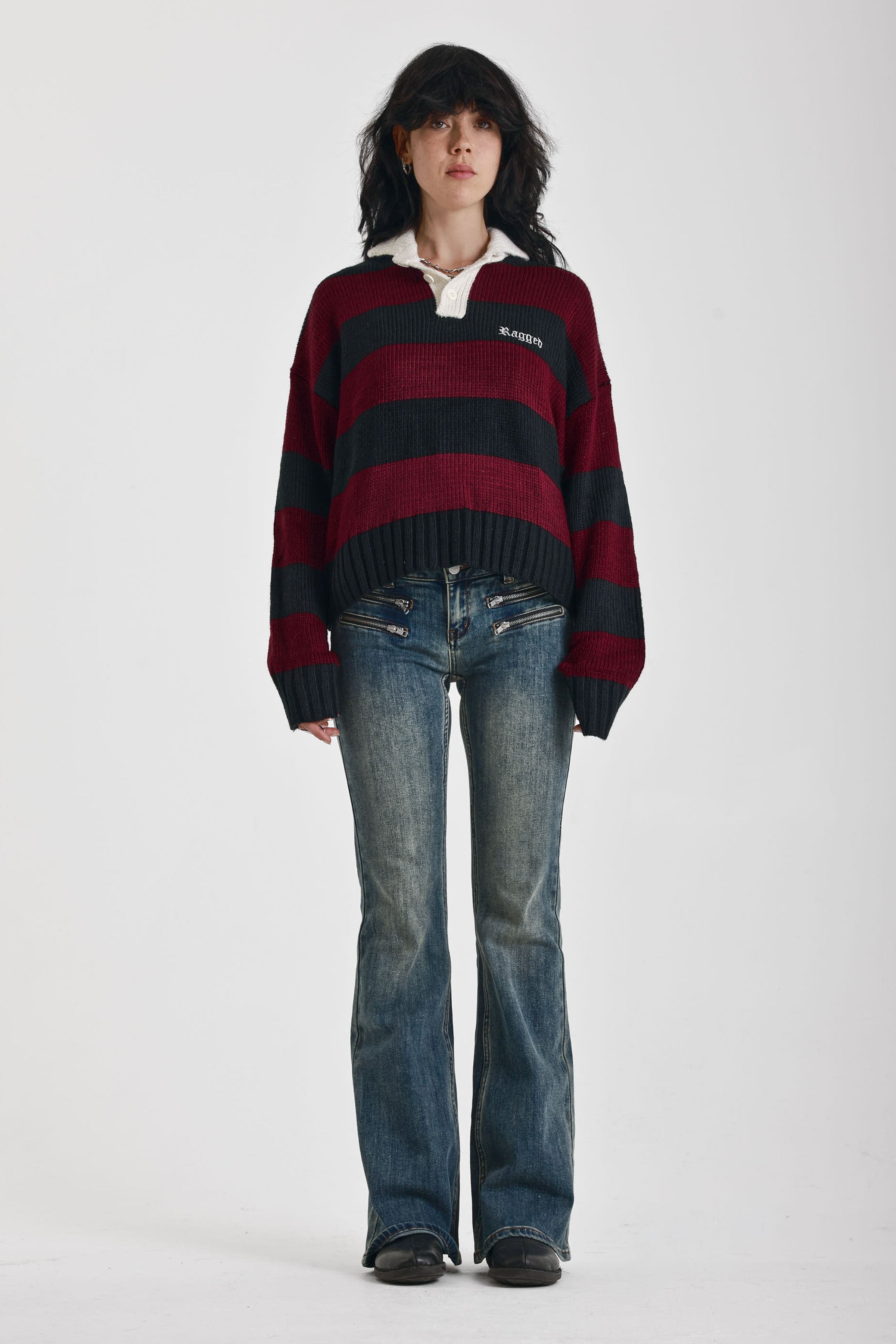 Burgundy and black striped rugby jumper with skull intarsia print, worn by model