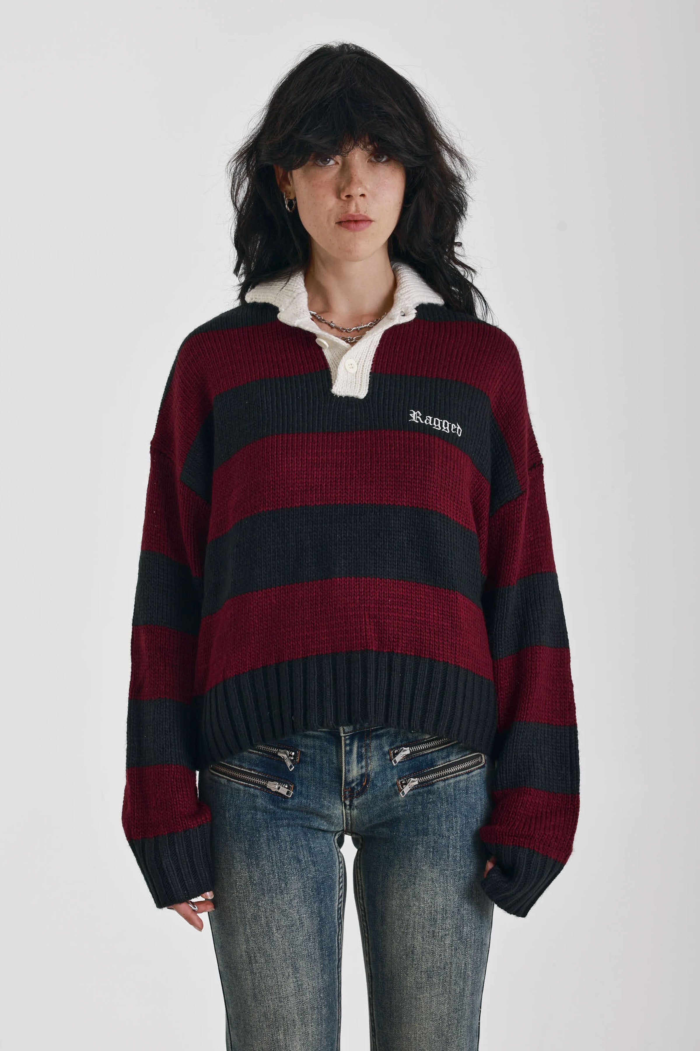 Burgundy and black striped rugby jumper with skull intarsia print, worn by model