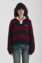 Burgundy and black striped rugby jumper with skull intarsia print, worn by model