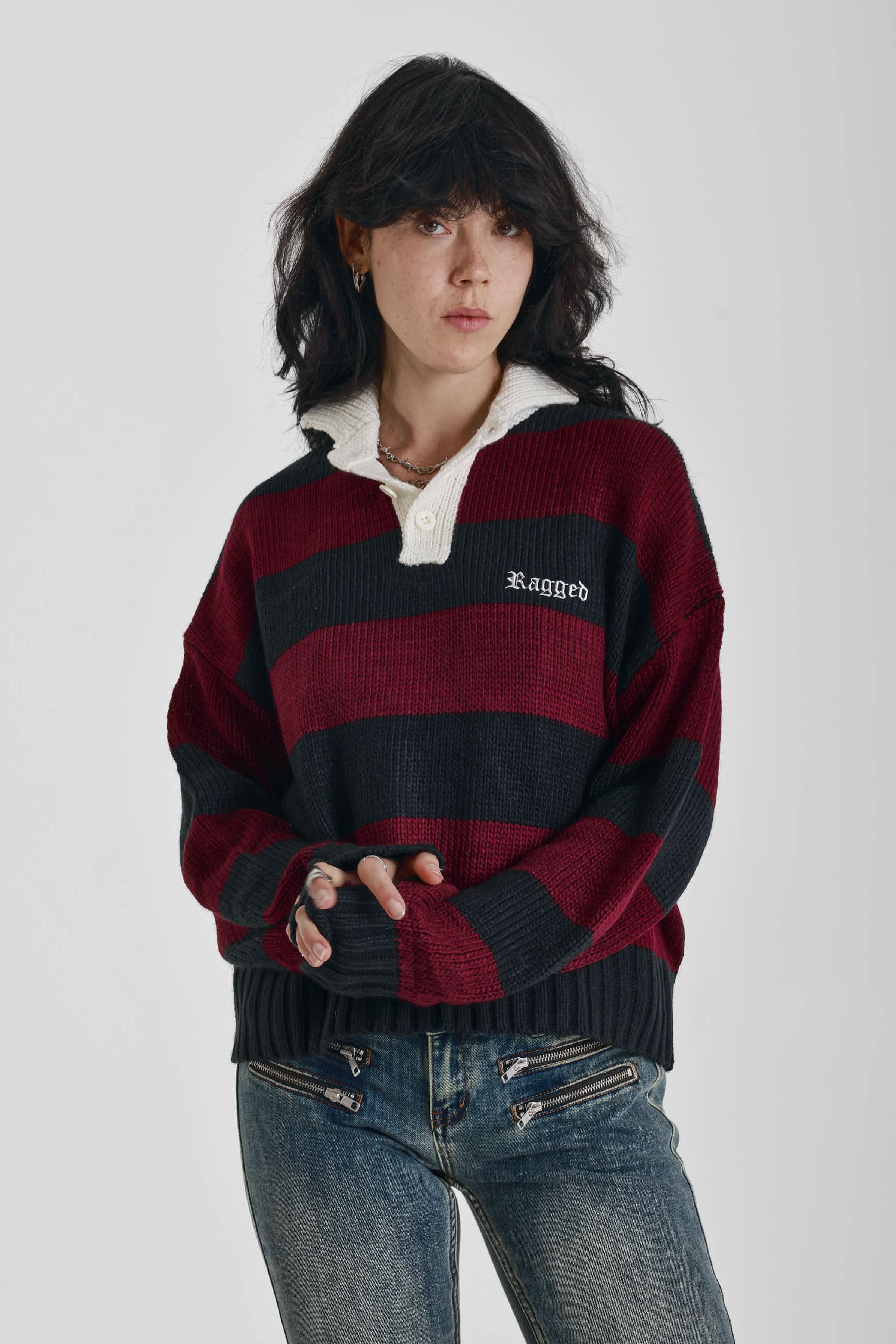 Burgundy and black striped rugby jumper with skull intarsia print, worn by model