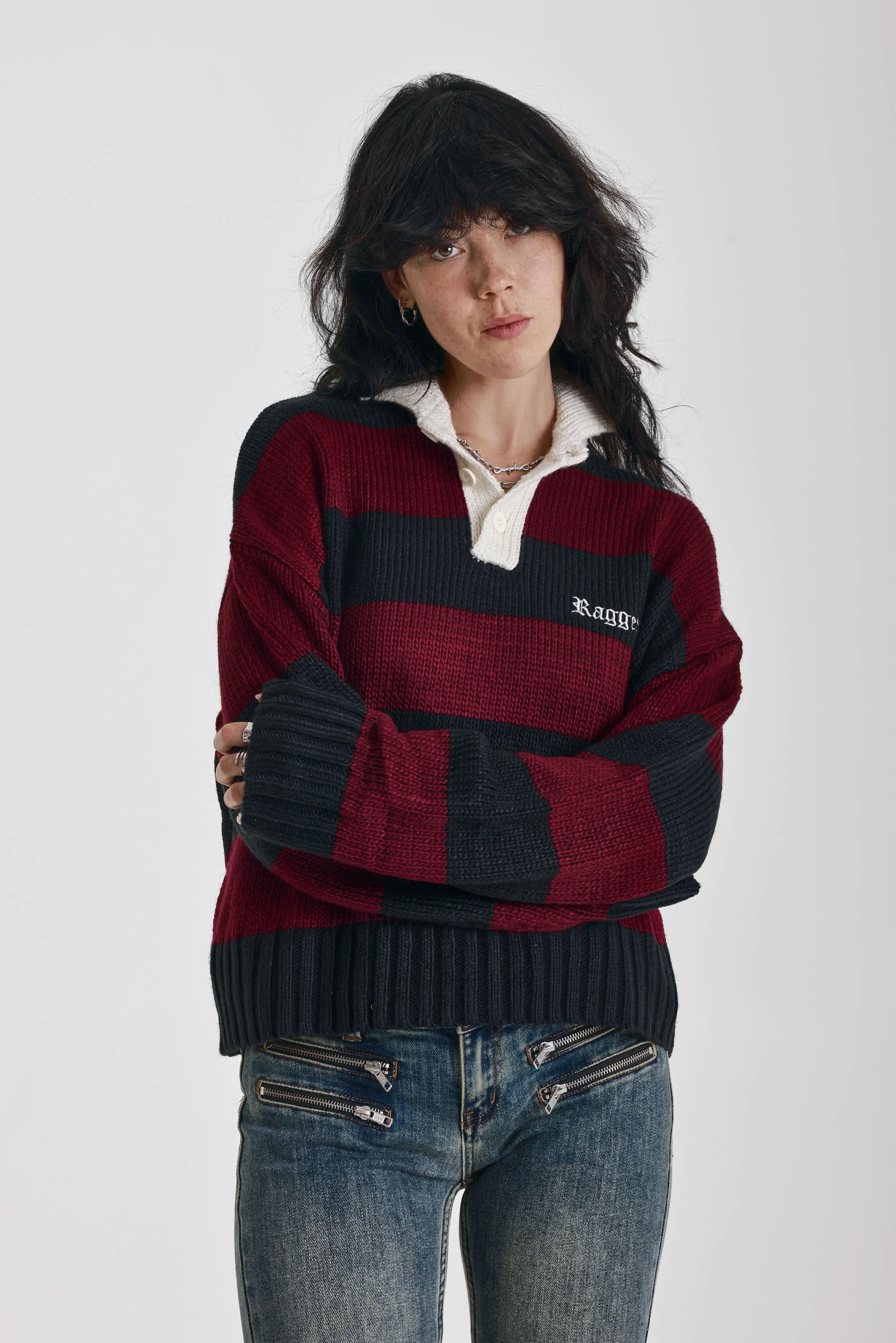 Burgundy and black striped rugby jumper with skull intarsia print, worn by model