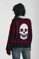 Burgundy and black striped rugby jumper with skull intarsia print, worn by model