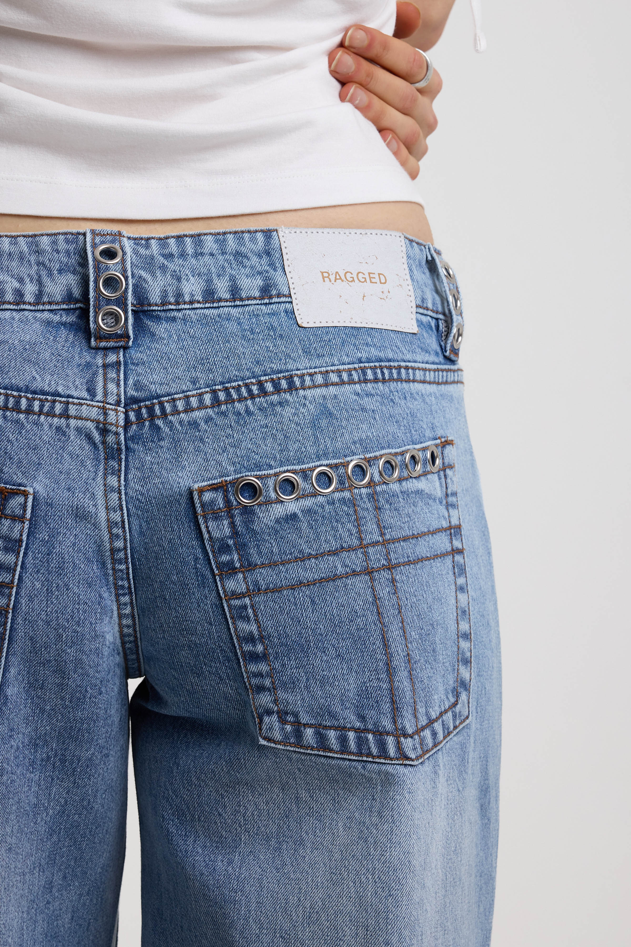 Washed blue denim relaxed straight leg jeans with lace up front and eyelet and rivet hardware, worn by model