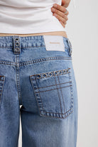 Washed blue denim relaxed straight leg jeans with lace up front and eyelet and rivet hardware, worn by model