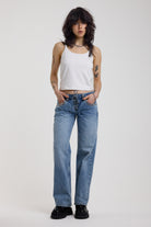 Washed blue denim relaxed straight leg jeans with lace up front and eyelet and rivet hardware, worn by model