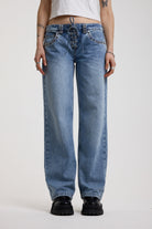 Washed blue denim relaxed straight leg jeans with lace up front and eyelet and rivet hardware, worn by model
