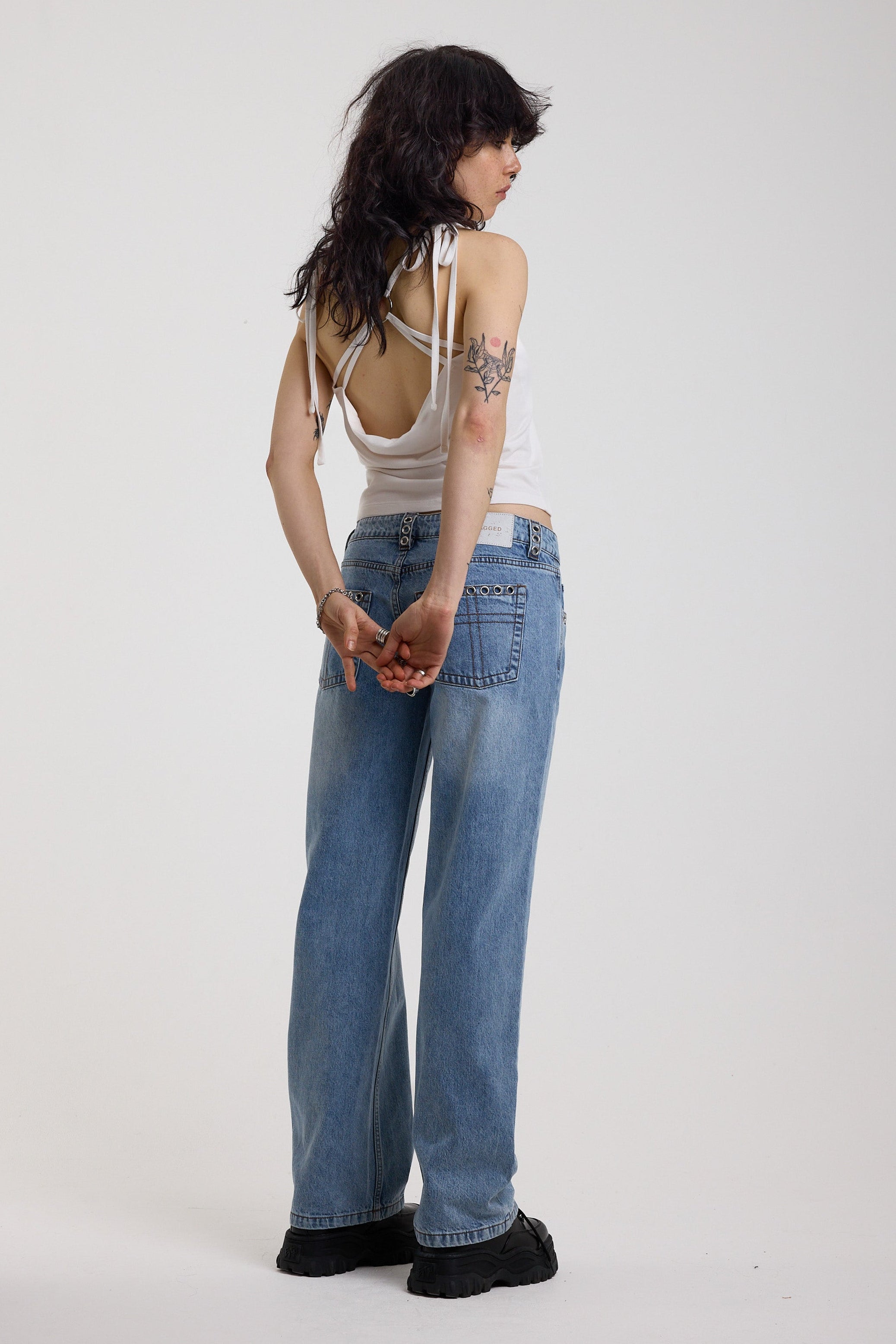 Washed blue denim relaxed straight leg jeans with lace up front and eyelet and rivet hardware, worn by model
