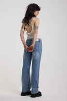 Washed blue denim relaxed straight leg jeans with lace up front and eyelet and rivet hardware, worn by model