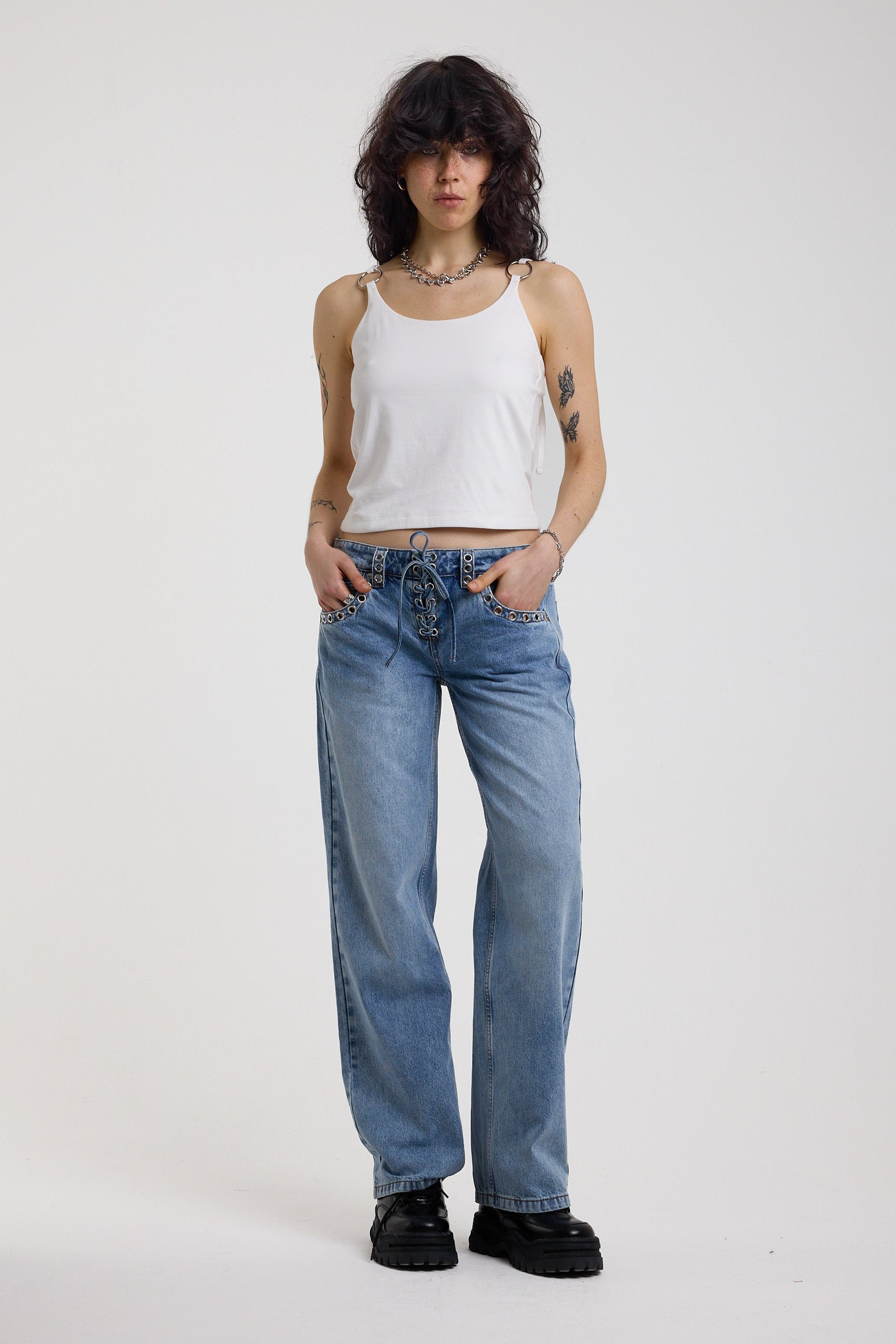 White strappy cami top with tie straps, cowl back and silver O rings, worn by model