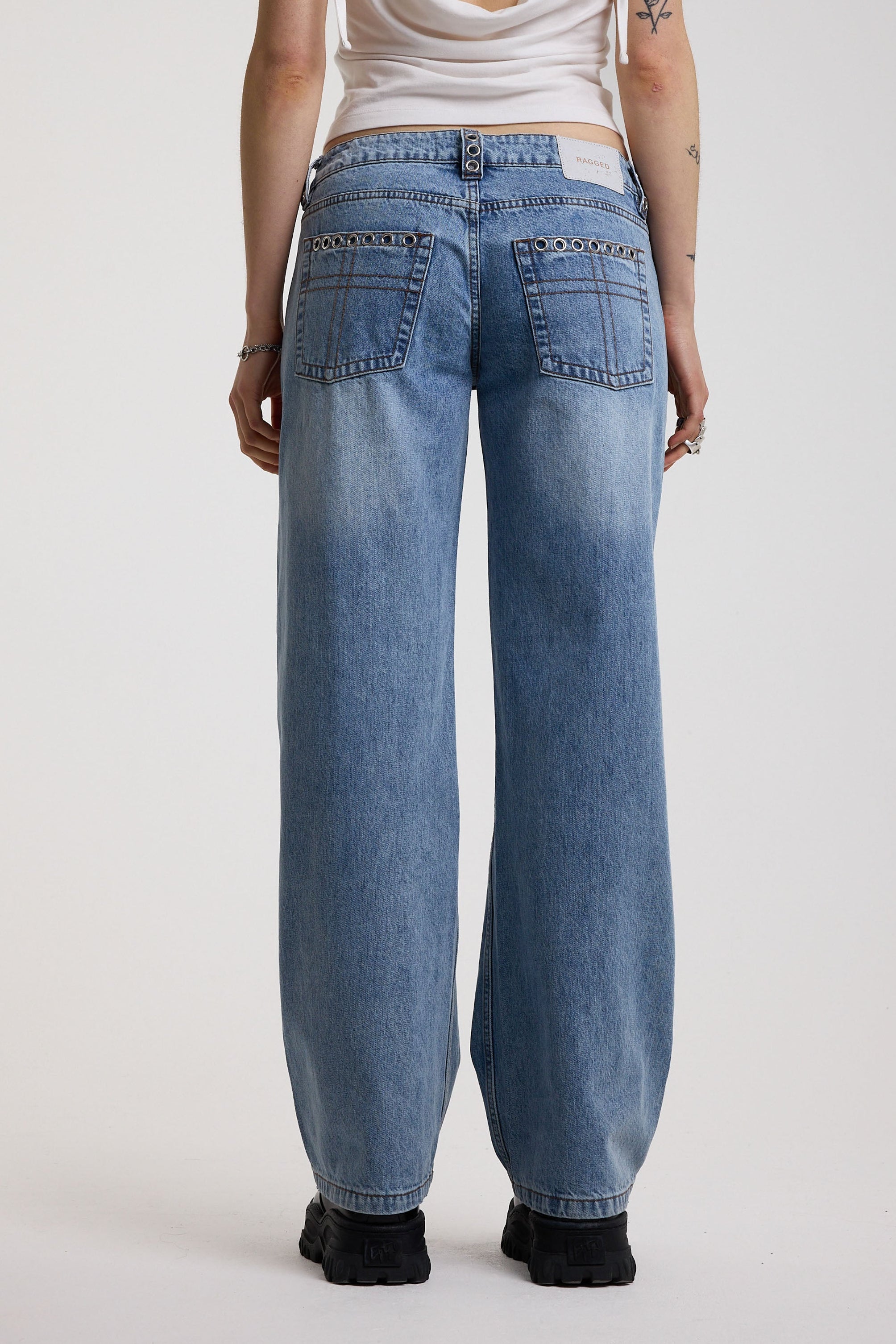 Washed blue denim relaxed straight leg jeans with lace up front and eyelet and rivet hardware, worn by model