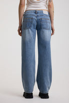 Washed blue denim relaxed straight leg jeans with lace up front and eyelet and rivet hardware, worn by model
