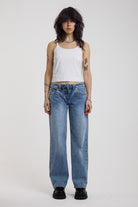 Washed blue denim relaxed straight leg jeans with lace up front and eyelet and rivet hardware, worn by model