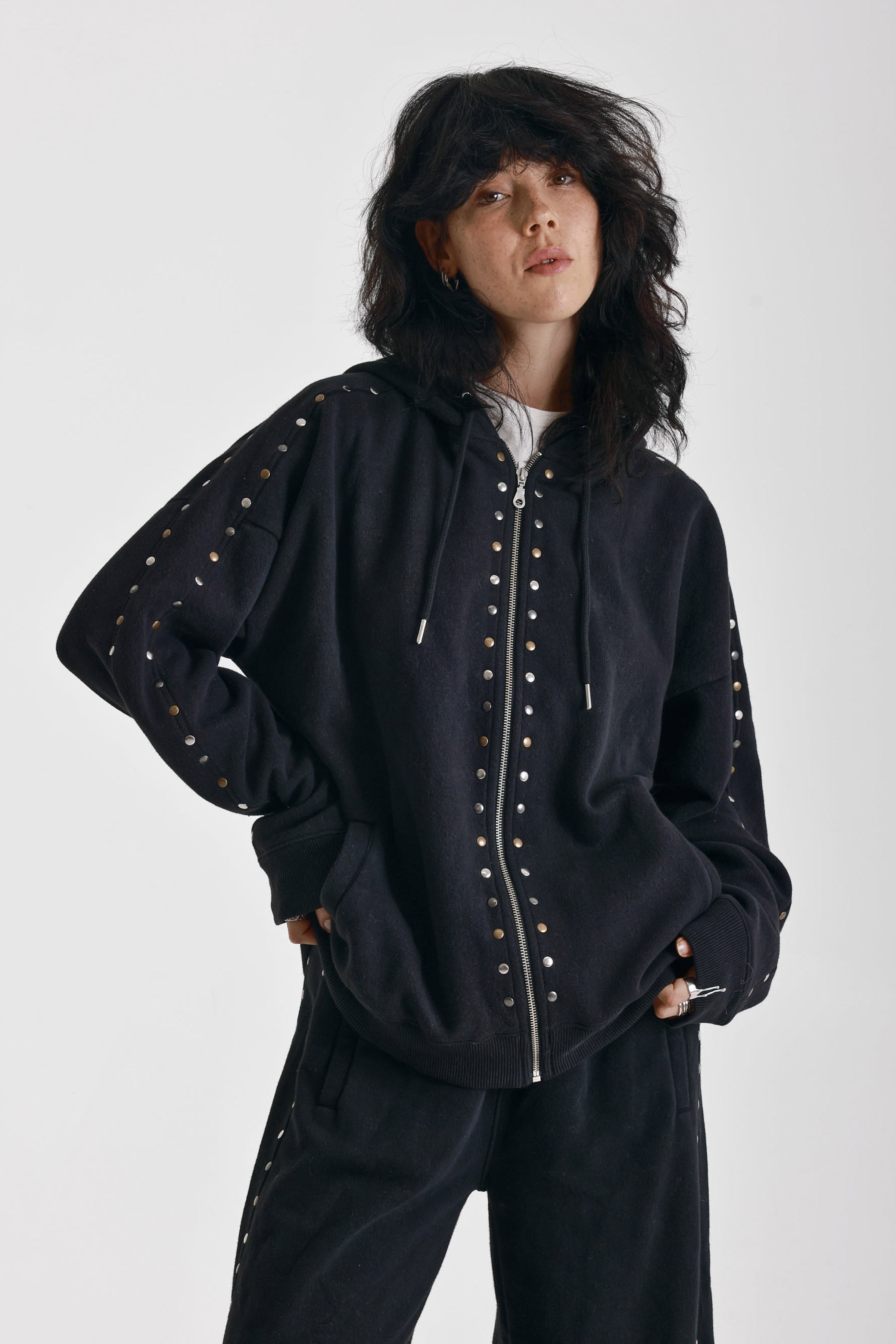 Washed black oversized zip up hoodie with mixed metal stud detail, worn by model