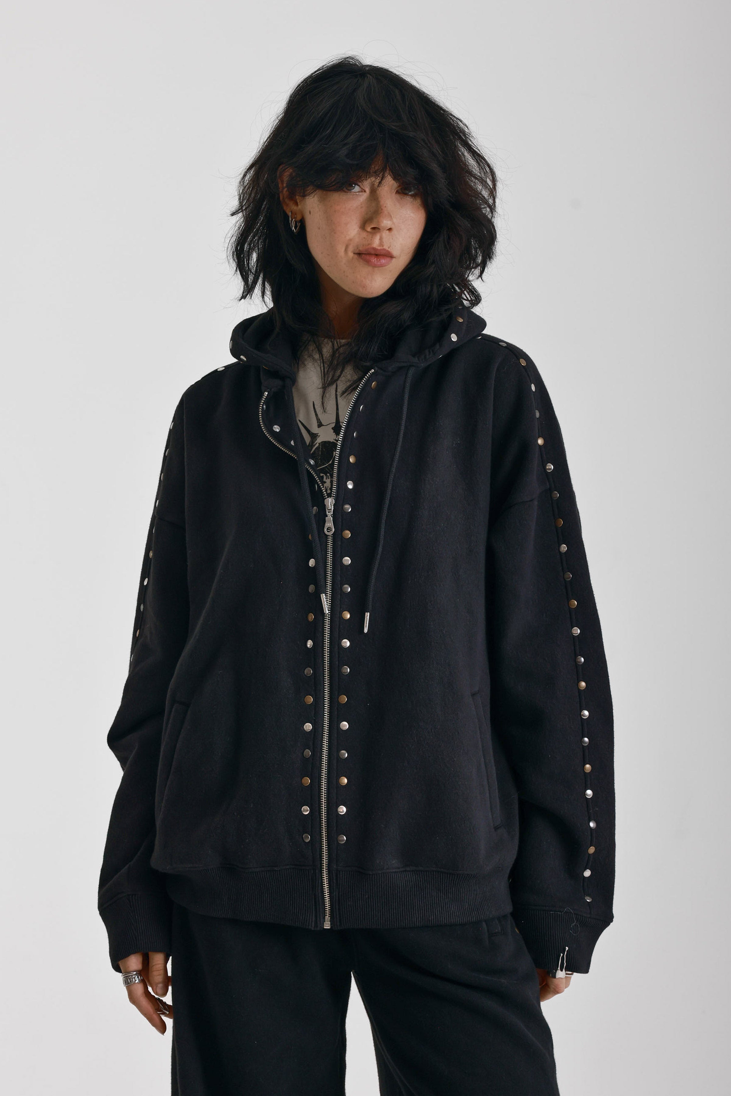 Washed black oversized zip up hoodie with mixed metal stud detail, worn by model