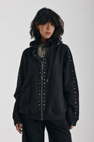 Washed black oversized zip up hoodie with mixed metal stud detail, worn by model