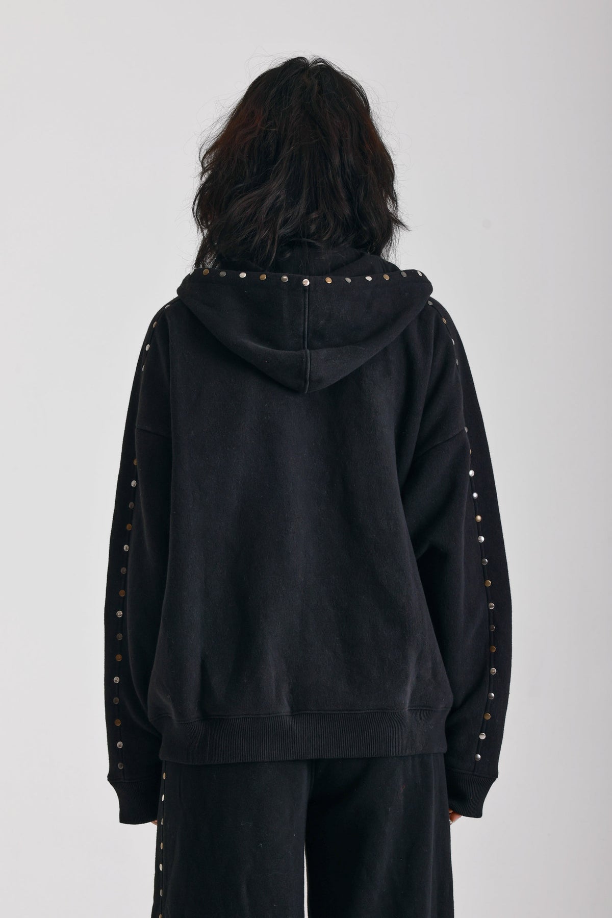 Washed black oversized zip up hoodie with mixed metal stud detail, worn by model