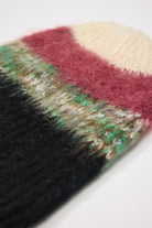 Black, green, pink and ecru textured fuzzy stripe knit beanie winter hat.