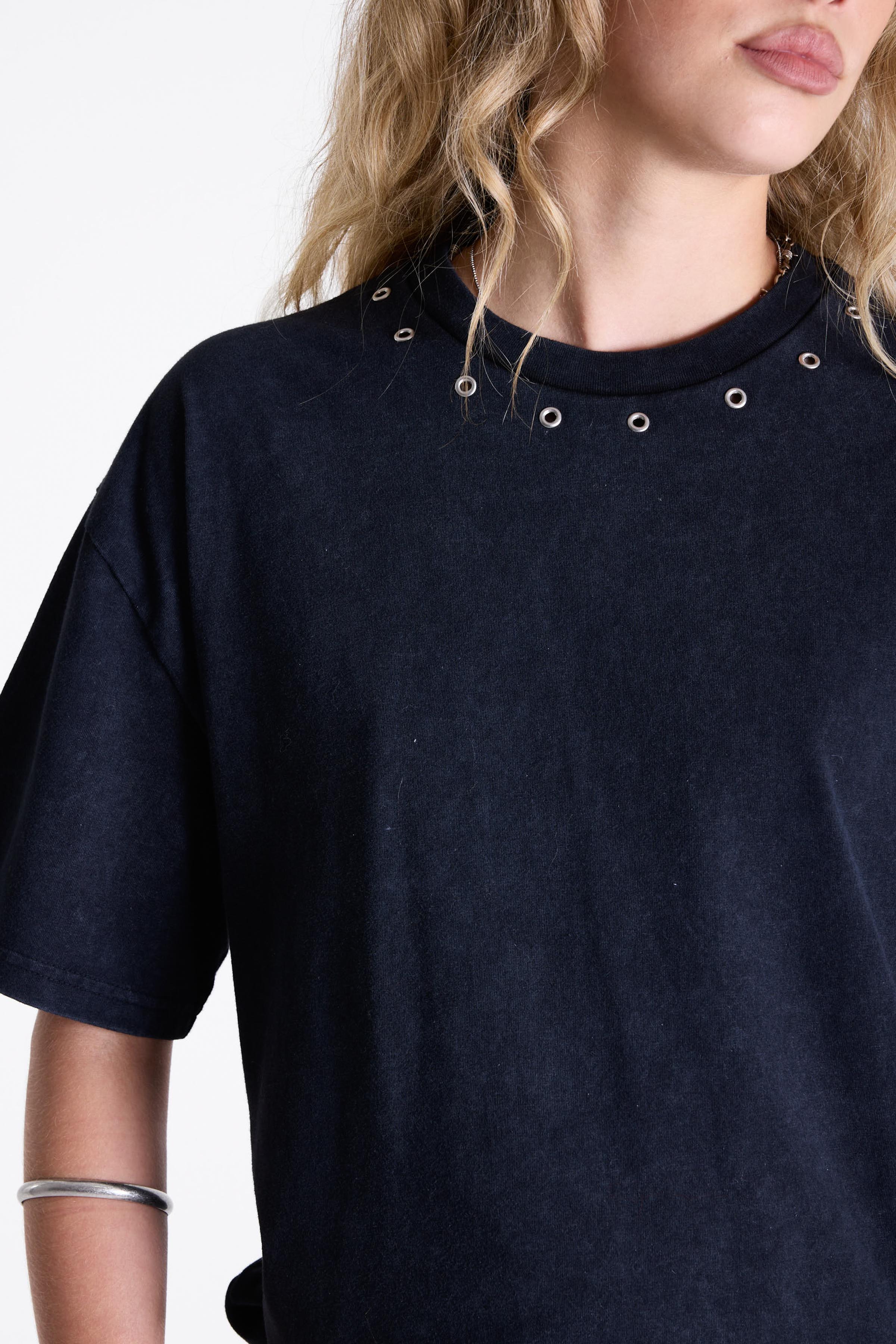 Acid wash black oversized t-shirt with silver eyelets and open back, worn by model