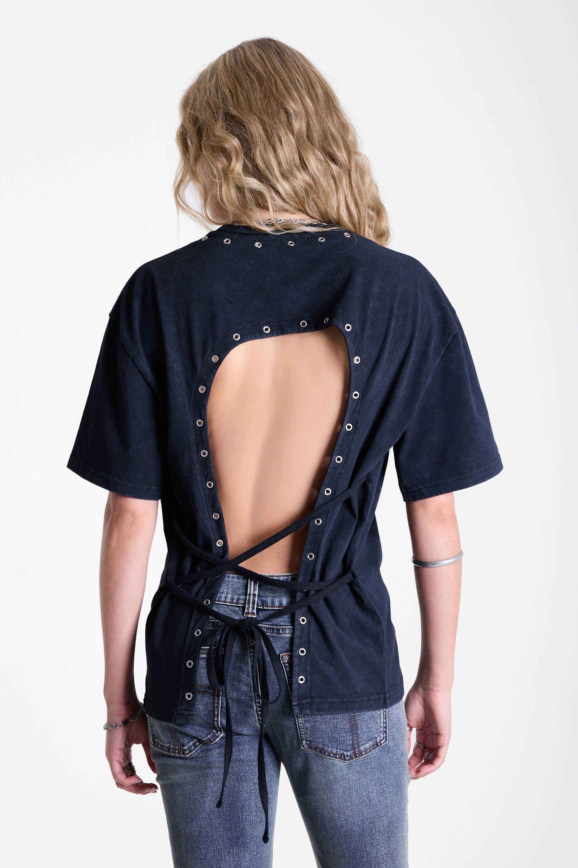 Acid wash black oversized t-shirt with silver eyelets and open back, worn by model