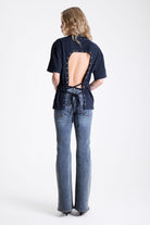 Acid wash black oversized t-shirt with silver eyelets and open back, worn by model