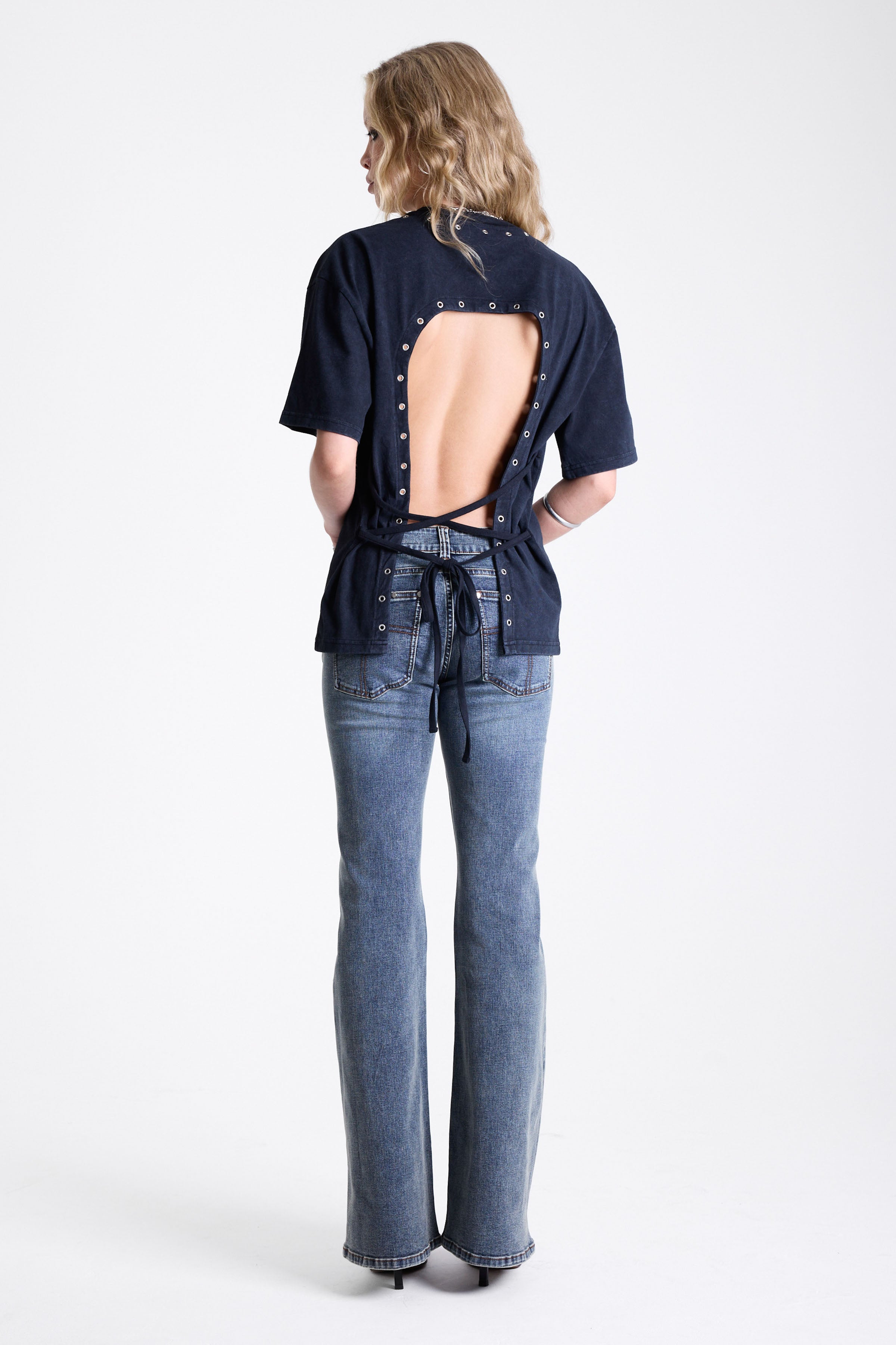 Acid wash black oversized t-shirt with silver eyelets and open back, worn by model