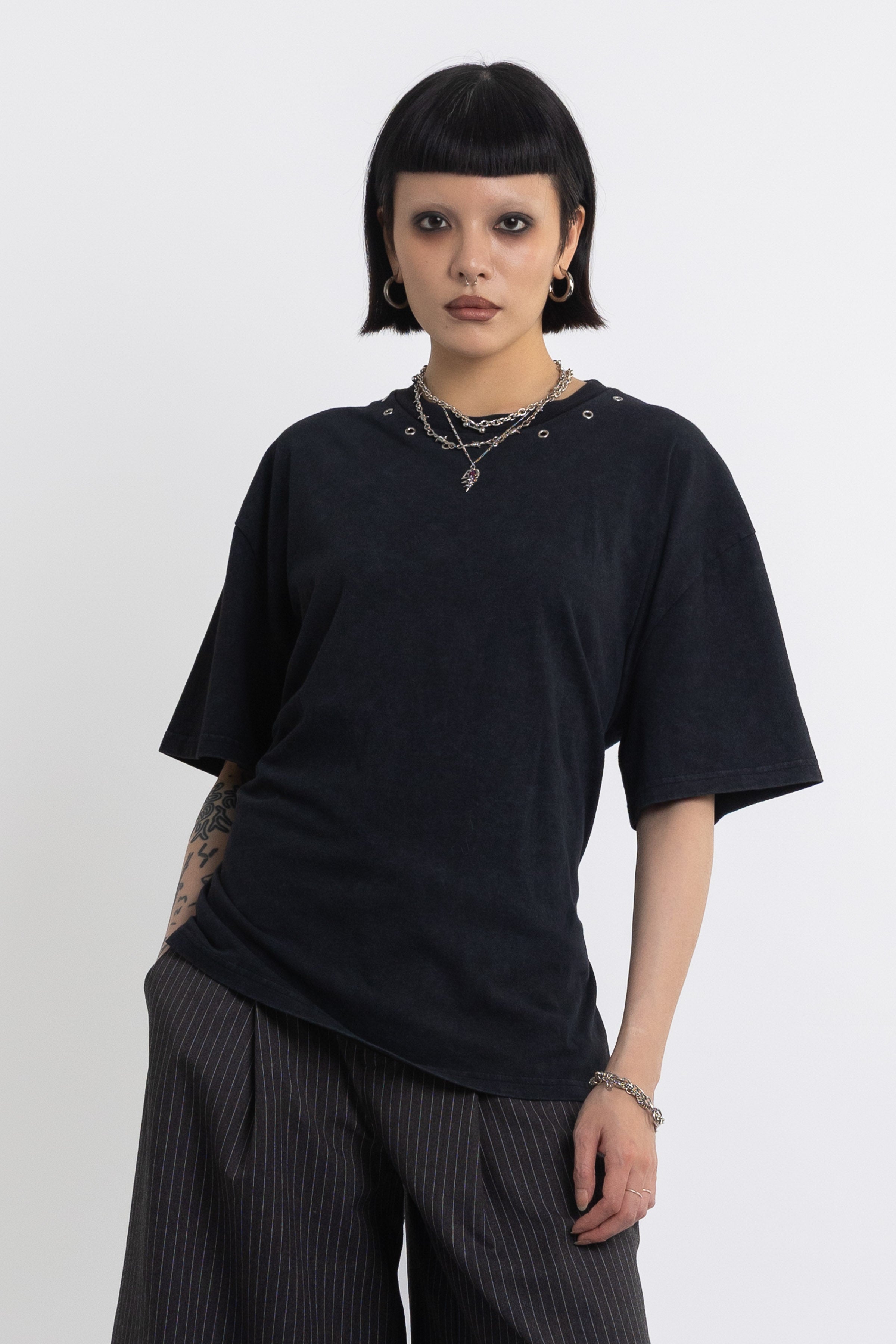 Black oversized t-shirt with open back and eyelet studs, worn by model