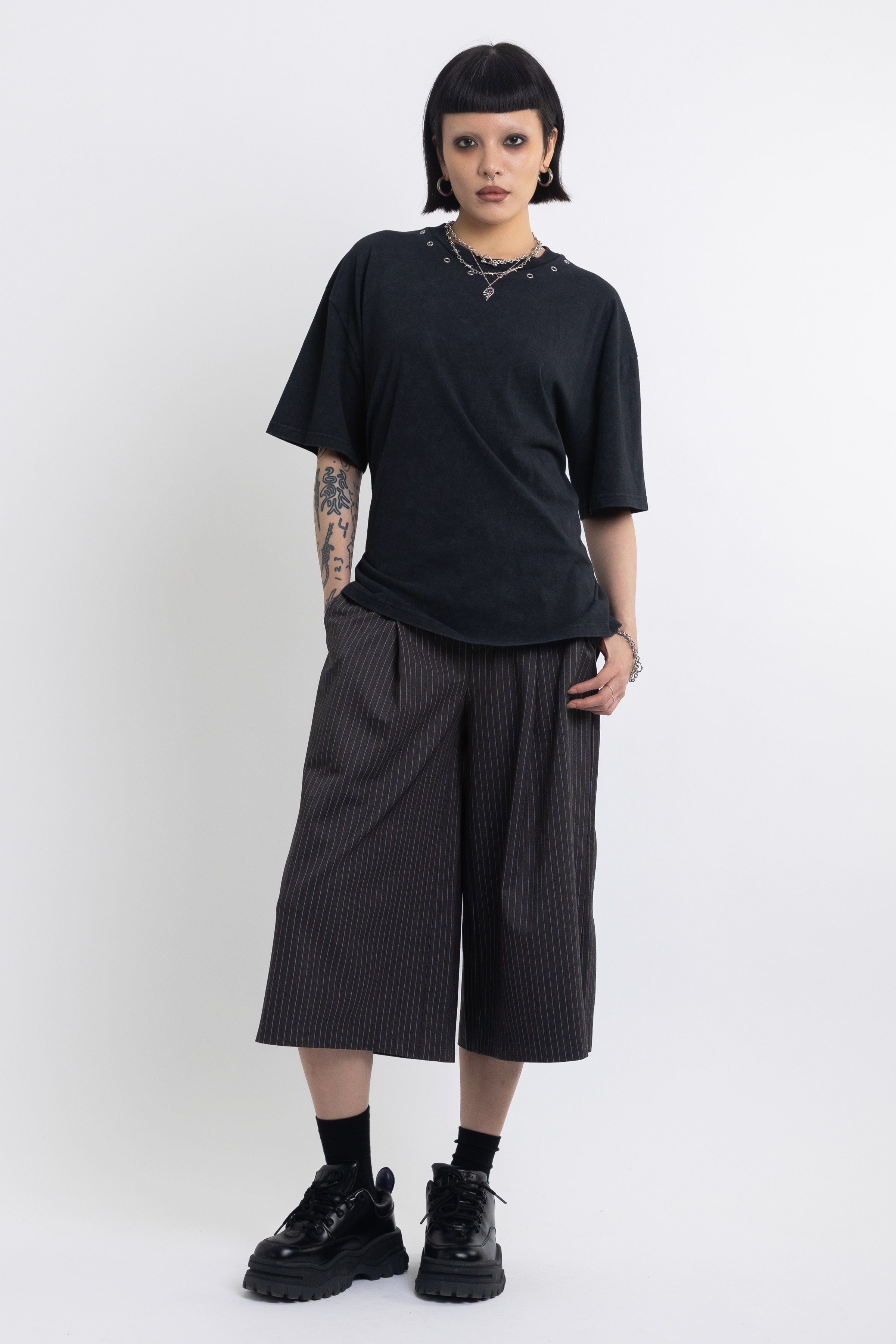 Black oversized t-shirt with open back and eyelet studs, worn by model