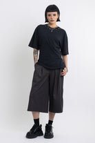 Black oversized t-shirt with open back and eyelet studs, worn by model