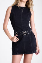Black denim mini dress with silver trigger clasp eyelet detail belt, worn by model
