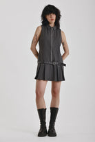 Grey pinstripe zip through mini dress with pleated skirt and silver eyelet belt and D-ring hardware, worn by model