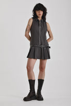 Grey pinstripe zip through mini dress with pleated skirt and silver eyelet belt and D-ring hardware, worn by model