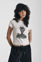 Ecru baby tee with black skeleton skull graphic print, worn by model