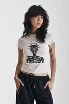 Ecru baby tee with black skeleton skull graphic print, worn by model